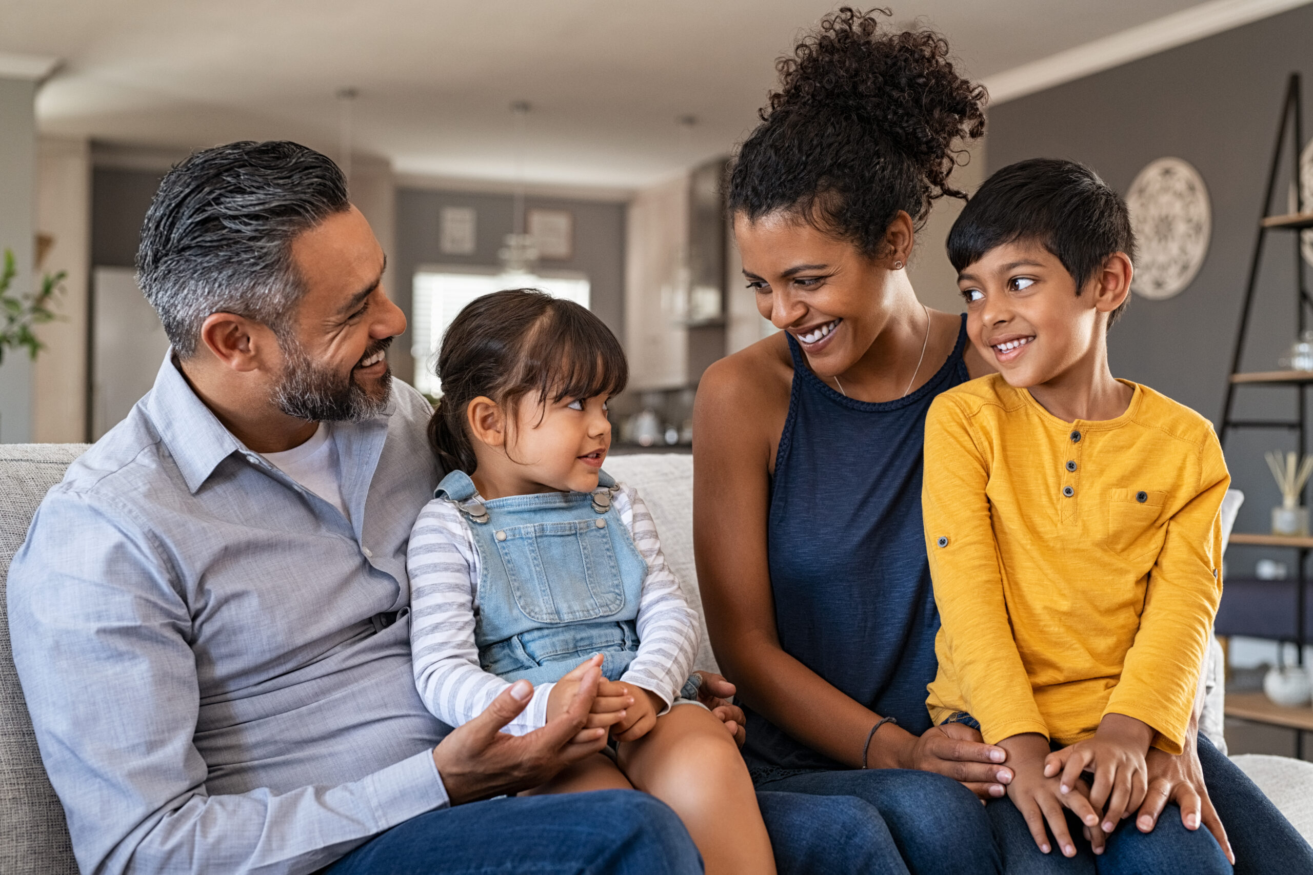 Happy ethnic family with two kids on couch img-6